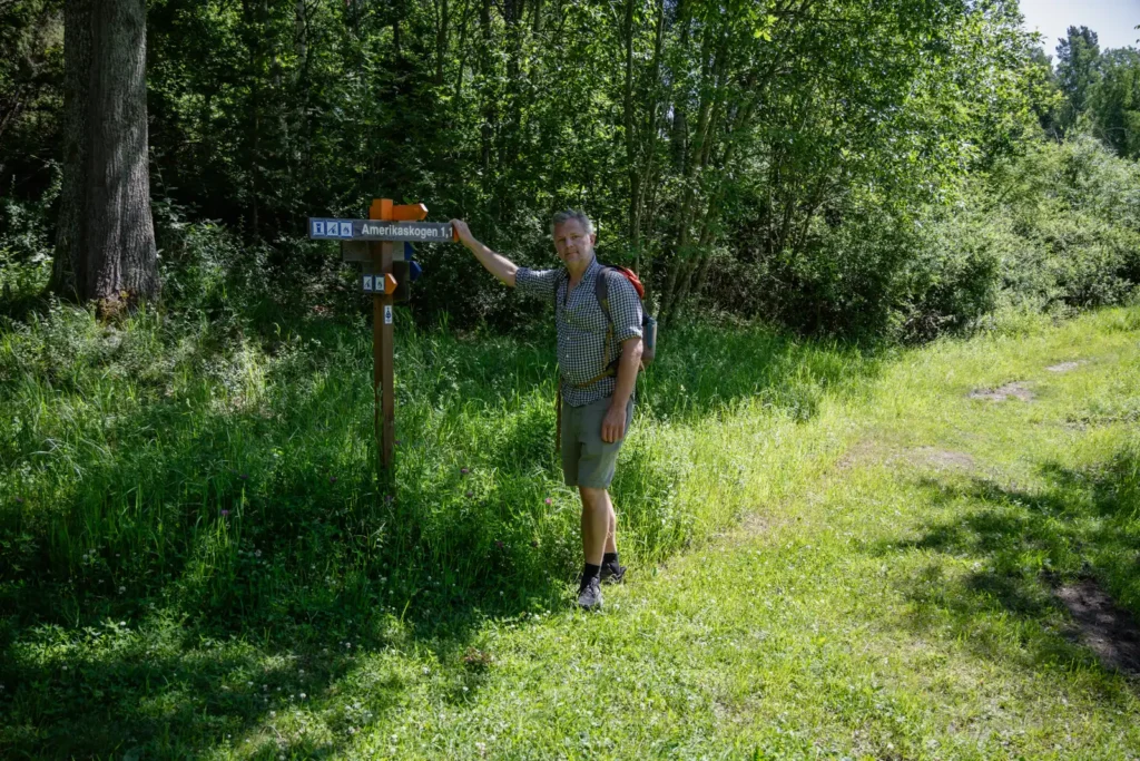 Vandrare vid vägvisare mot Amerikaskogen längs Upplandsleden mellan Lillkyrka och Veckholm.